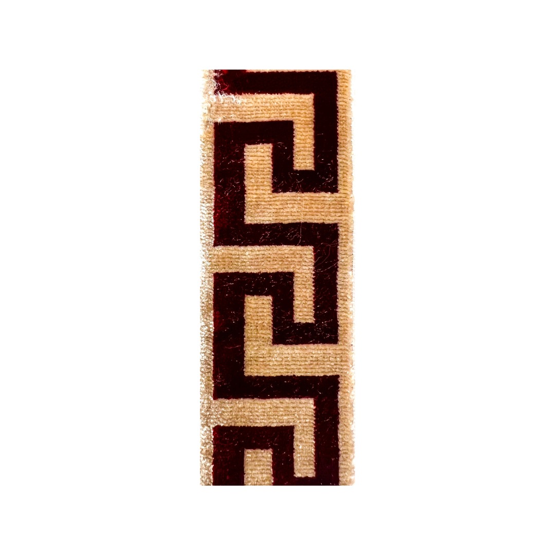 Close-up of burgundy velvet fabric with ivory geometric design used for the Ambra Custom Stamped Cuff Bracelet, handcrafted in Shreveport, LA by Redd Dott Jewelry.