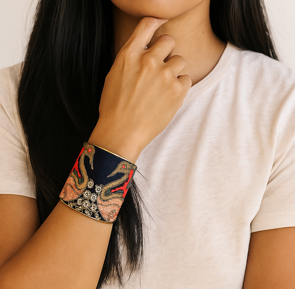 Woman wearing the Annalee Brass Cuff Bracelet featuring gold swan embroidery on navy fabric with red and coral accents, handcrafted in Shreveport, LA by Redd Dott Jewelry.