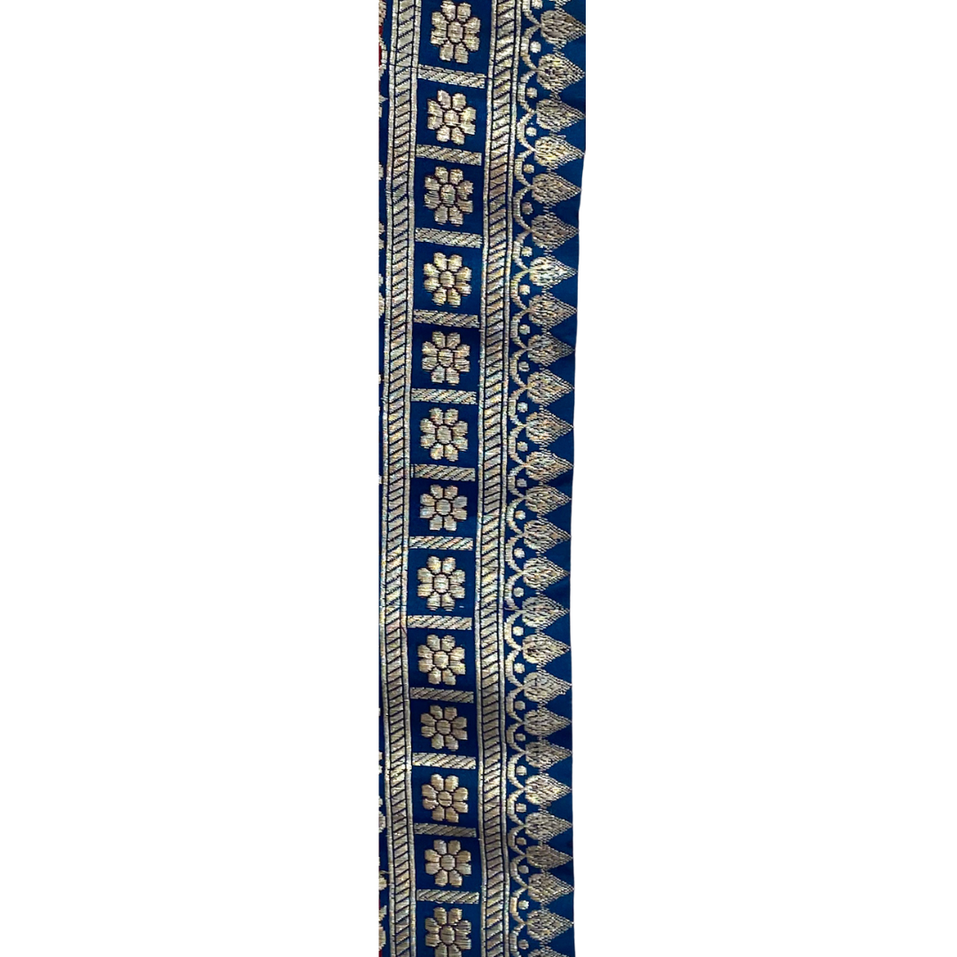 A Vintage Brass Bracelet by Redd Dott Jewelry, featuring intricate silver floral motifs against a royal blue background. 