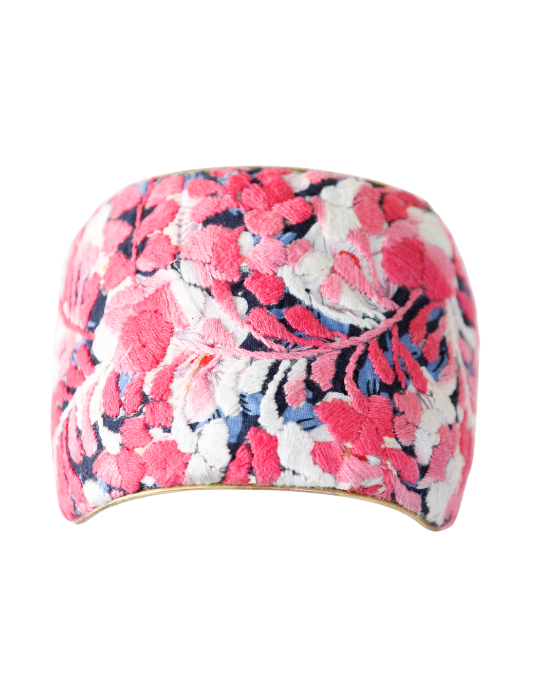 three-inch Flor De Alma embroidered brass cuff bracelet bursting with coral and pink flowers over deep navy blue textile.