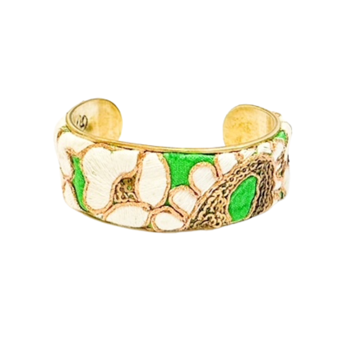 Close-up of Gina floral cuff bracelet showing embroidered white flowers, gold details, and green highlights on brass, an elegant handmade bracelet, handcrafted in Shreveport, LA by Redd Dott Jewelry.