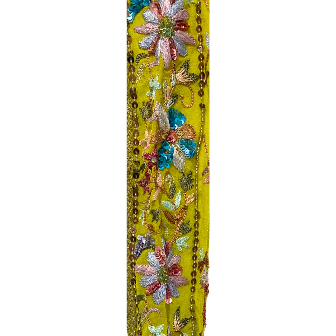 Vintage brass bracelet with a bright green fabric base, detailed multicolored floral embroidery, shimmering sequins, and beadwork, custom-stamped and handmade by Redd Dott Jewelry.
