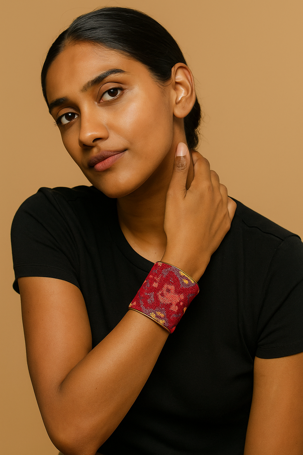 A female model wears a three-inch brass cuff bracelet wrapped in red and gold geometric tapestry fabric
