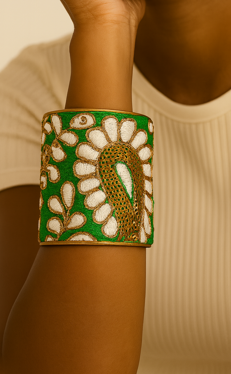 Model wearing the large green Gina cuff bracelet featuring embroidered white petals and a gold paisley motif, a bold botanical handmade jewelry design handcrafted in Shreveport, LA by Redd Dott Jewelry.