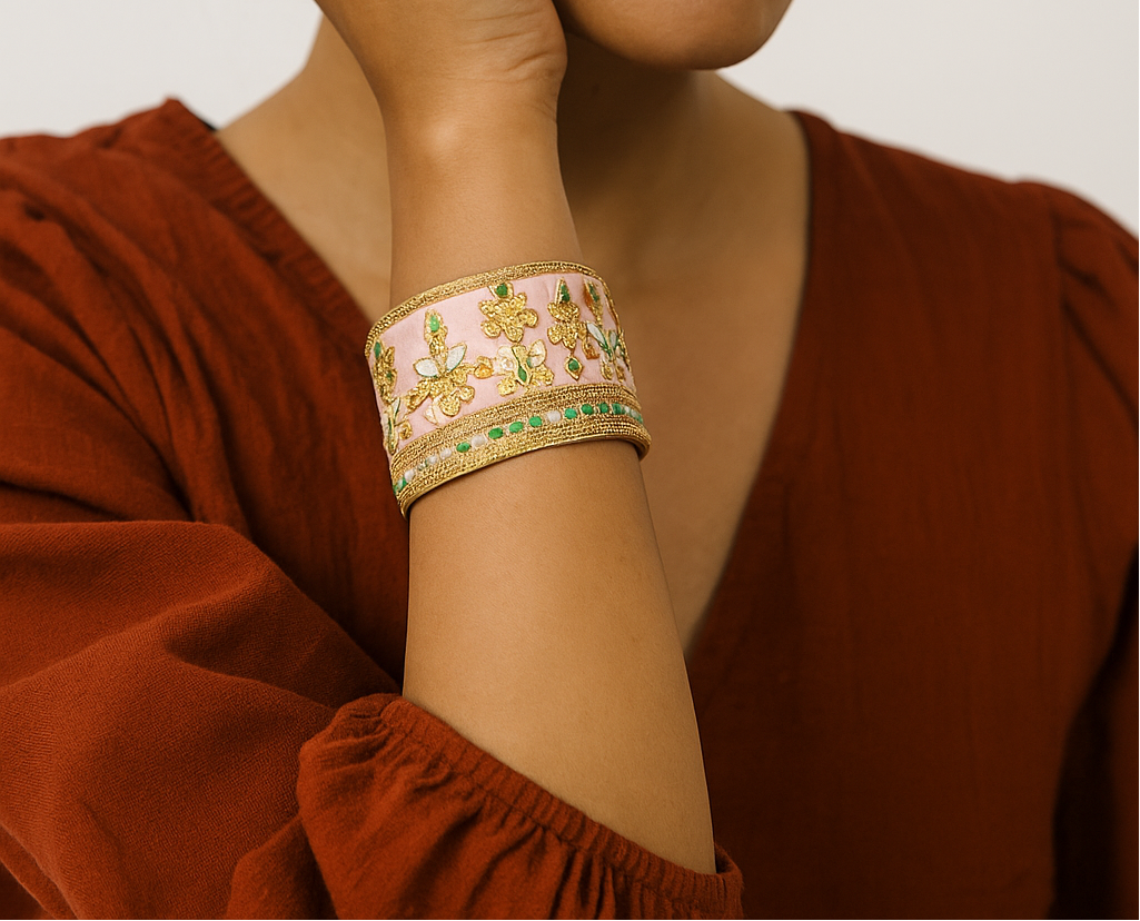 Woman wearing the Amelia Custom Stamped Cuff Bracelet featuring blush silk, gold embroidery, and green floral details on brass, handcrafted in Shreveport, LA by Redd Dott Jewelry.
