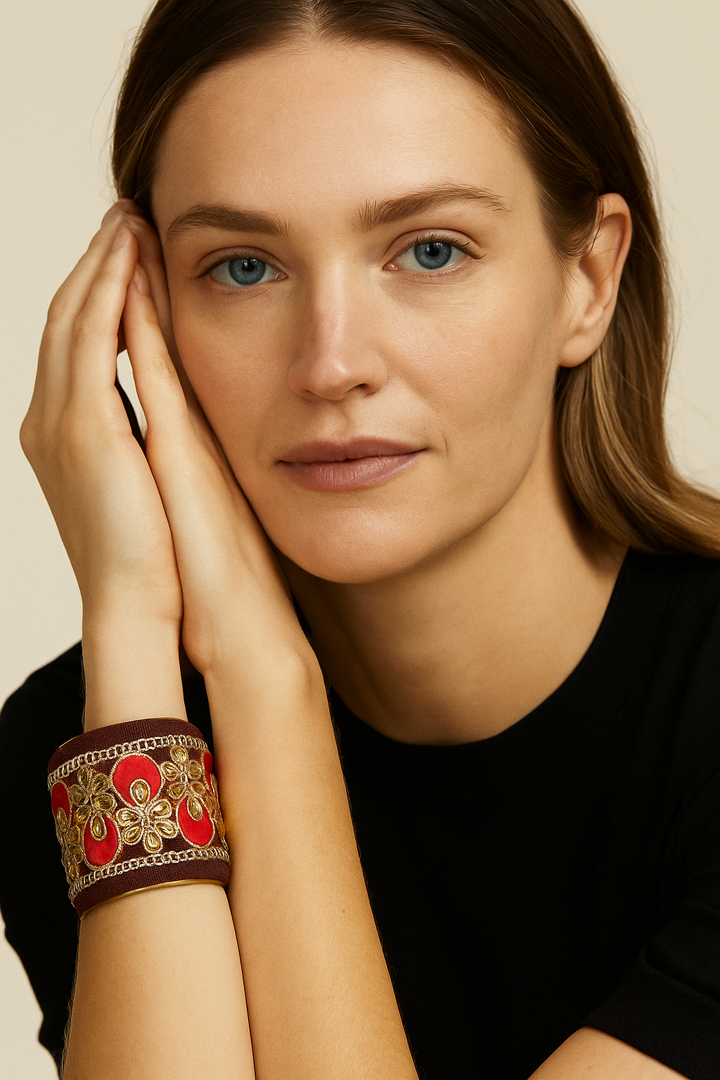 A female model’s wrist adorned with a 3-inch raw brass cuff bracelet featuring burgundy embroidery with red petals, gold floral motifs, and sparkling sequins—an elegant one of a kind jewelry statement in cuff bracelets for women.