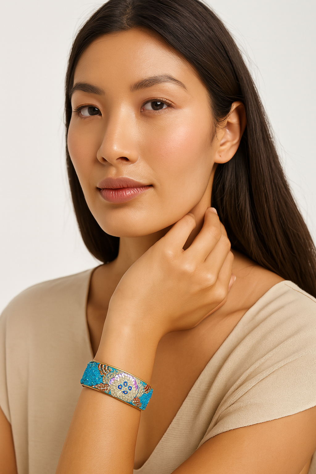 A female model’s wrist adorned with a 1-inch raw brass cuff bracelet featuring turquoise embroidered fabric with gold and pink sequin detailing in a starburst design, a one of a kind jewelry statement among cuff bracelets for women.