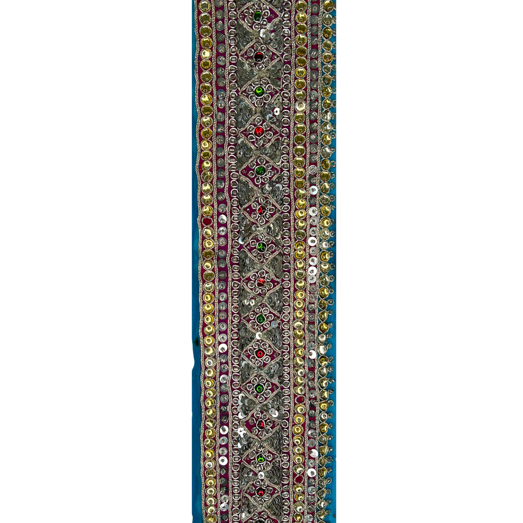 A statement cuff bracelet by Redd Dott Jewelry, featuring intricate metallic embroidery, gemstone embellishments, and shimmering sequins on a bold blue background. 