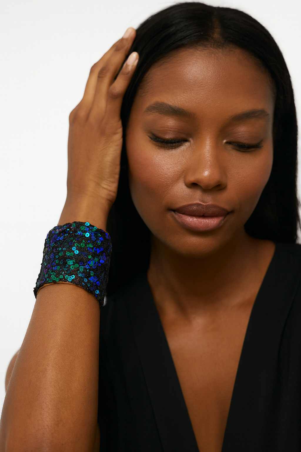 Redd Dott Mardi 24/7 3-inch cuff bracelet covered in shimmering black, blue, and green sequins that shift with the light, framed in brass, creating a bold and glamorous statement piece for round-the-clock celebration.
