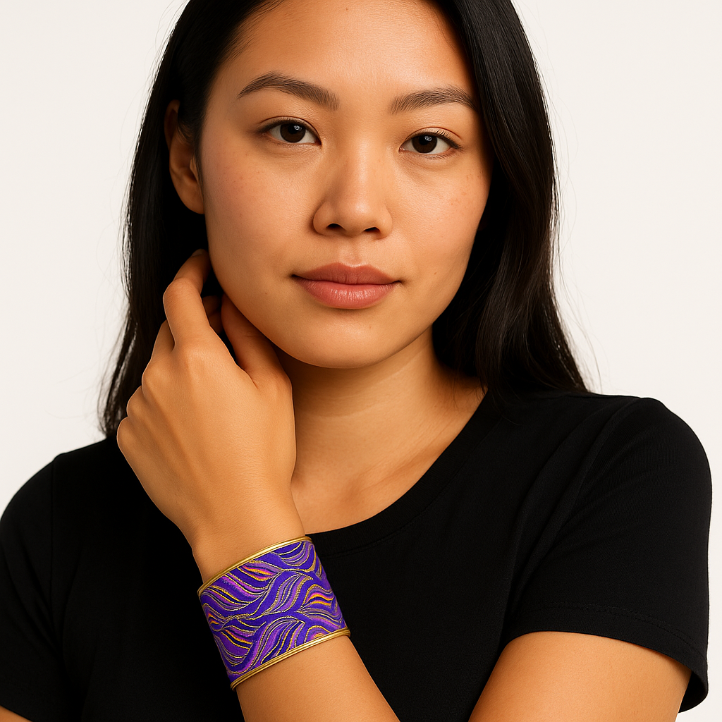 Front view of the Redd Dott Mardi Time 2-inch cuff bracelet, featuring flowing purple and gold wave-like embroidery framed in polished brass, inspired by the rhythm and energy of Mardi Gras.