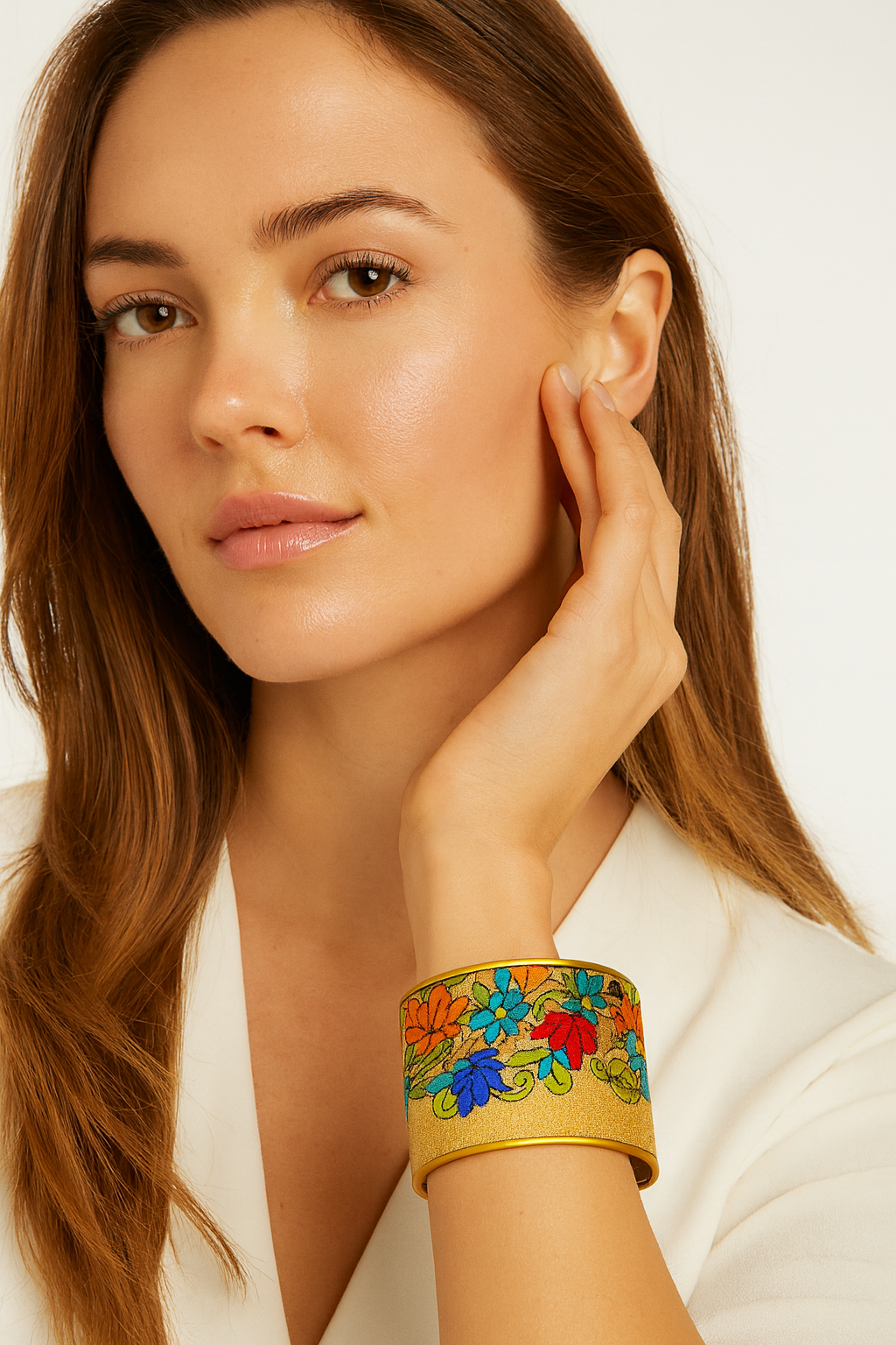 Model wearing the Redd Dott Marissa 3-inch cuff bracelet, featuring a golden base adorned with vivid embroidered flowers in shades of red, blue, green, and orange, framed with a polished gold edge for a radiant, statement look.