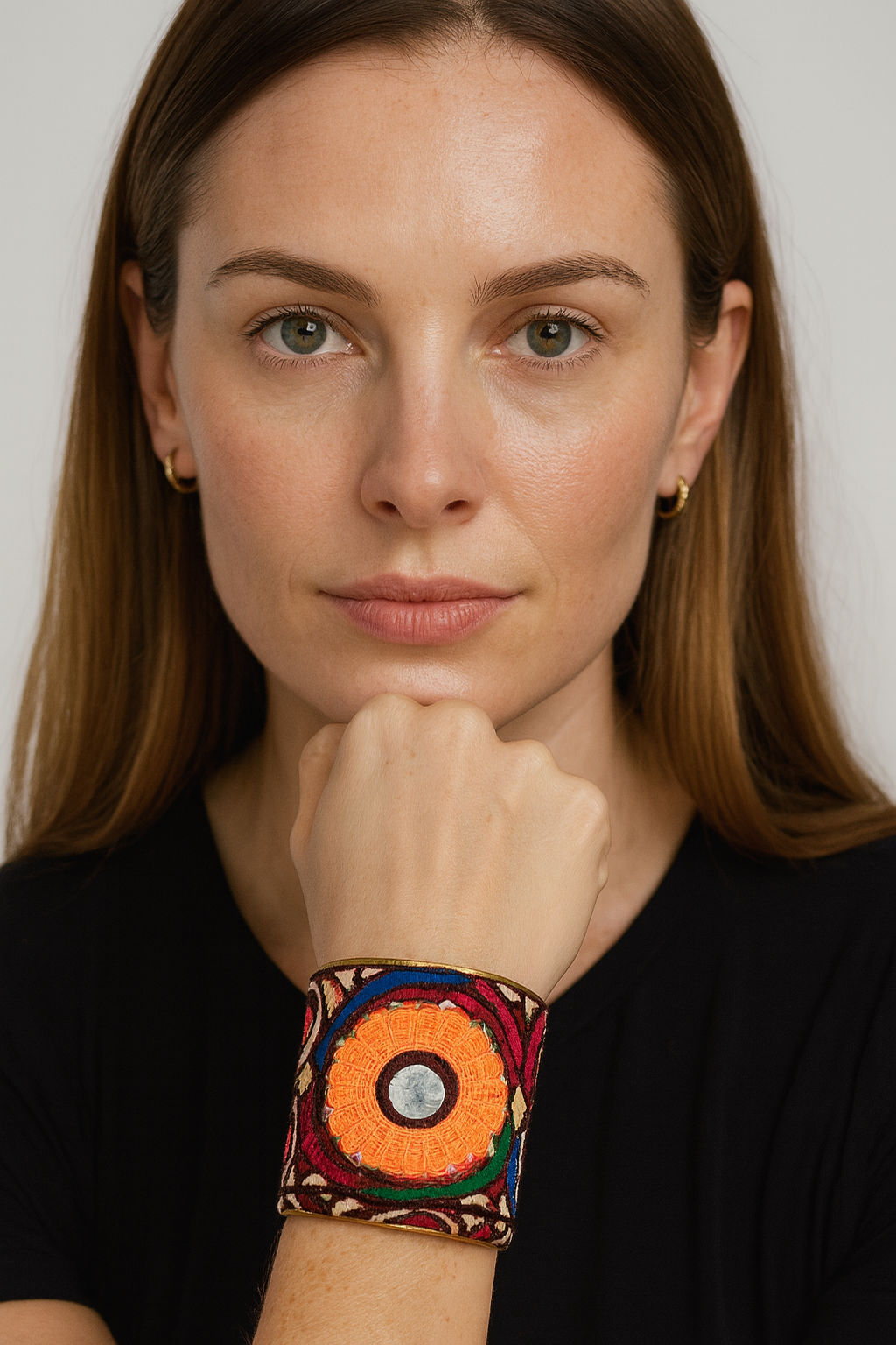 Model wearing the Redd Dott Moxie 3-inch cuff bracelet, featuring bold embroidery in vivid orange, red, and green with a central mirror accent, framed in gold for a striking bohemian statement.