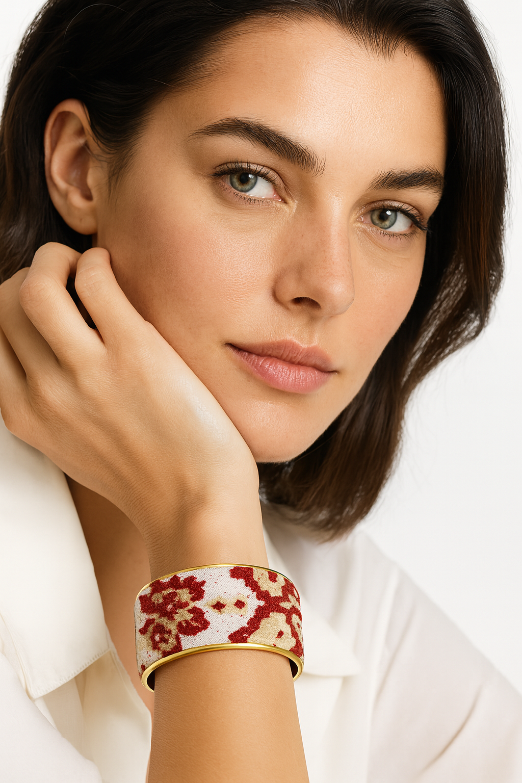 Model wearing the Redd Dott Natalya 2-inch cuff bracelet, featuring a textured ivory base with bold red floral patterns, framed in sleek gold for a refined yet romantic statement.