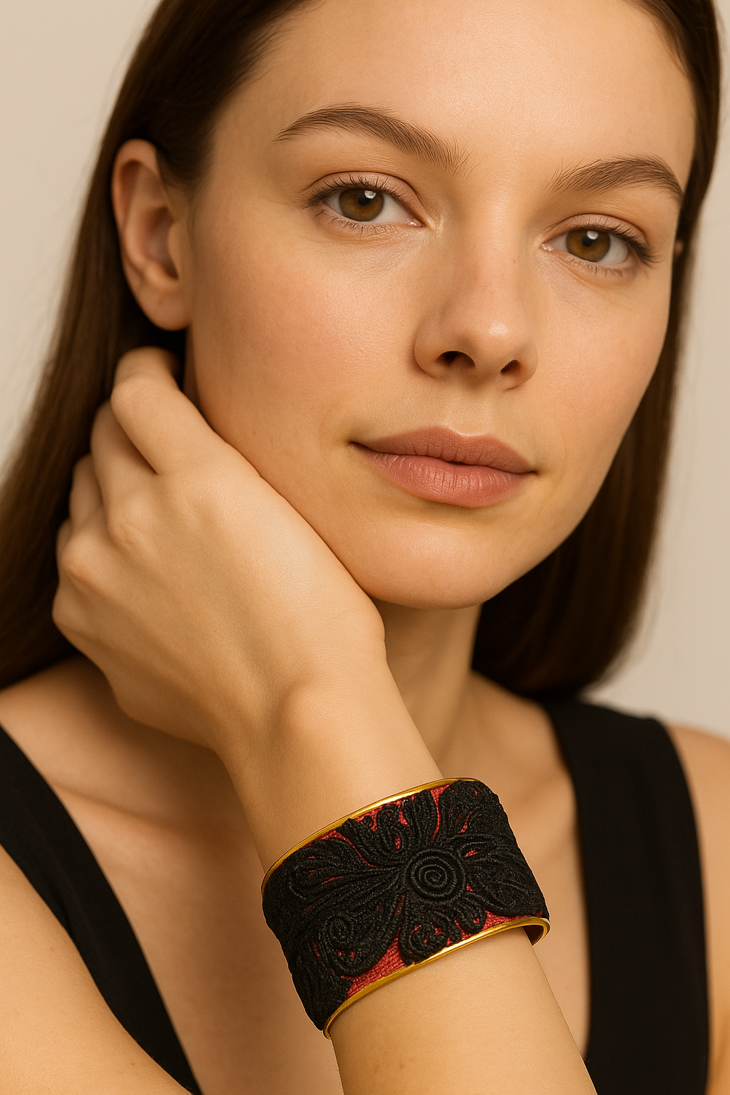 Model wearing the Redd Dott Natasha 2-inch cuff bracelet, featuring bold black floral embroidery layered over a rich red base, framed in polished gold for a striking and elegant statement.