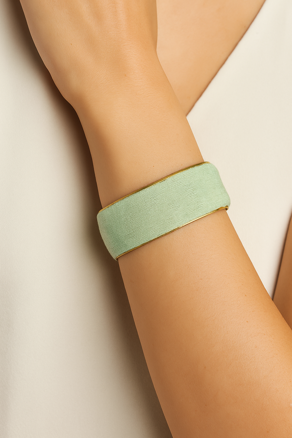 Close-up of the Redd Dott Owlen 1-inch cuff bracelet in soft mint-green fabric with a smooth finish, framed by subtle gold edging for an elegant, minimalist style.