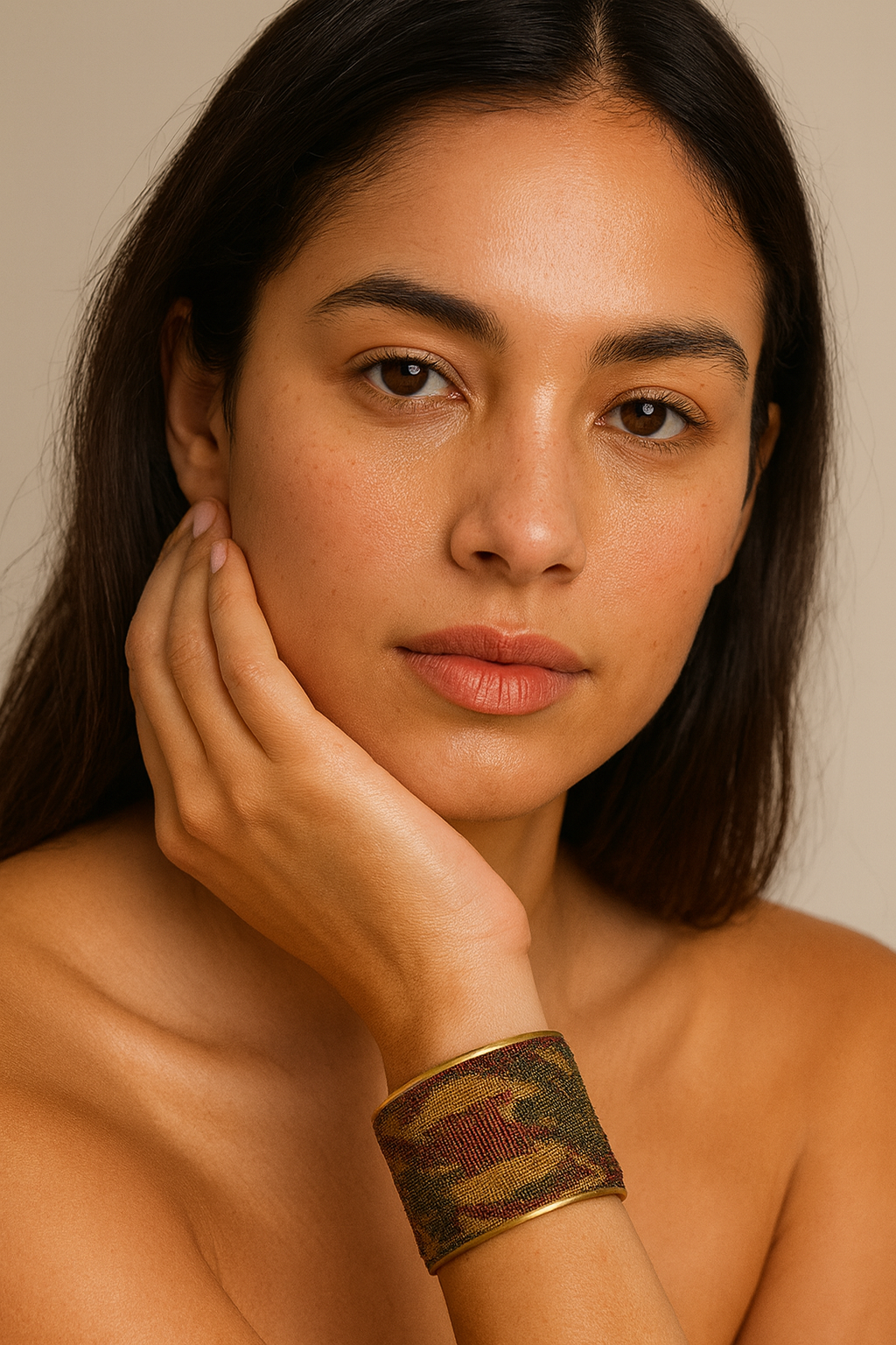 Woman wearing the Redd Dott Paisley 2-inch cuff bracelet, a refined piece featuring a muted tapestry-like fabric with earthy green, gold, and burgundy tones in a subtle paisley-inspired pattern, framed with sleek gold edging.