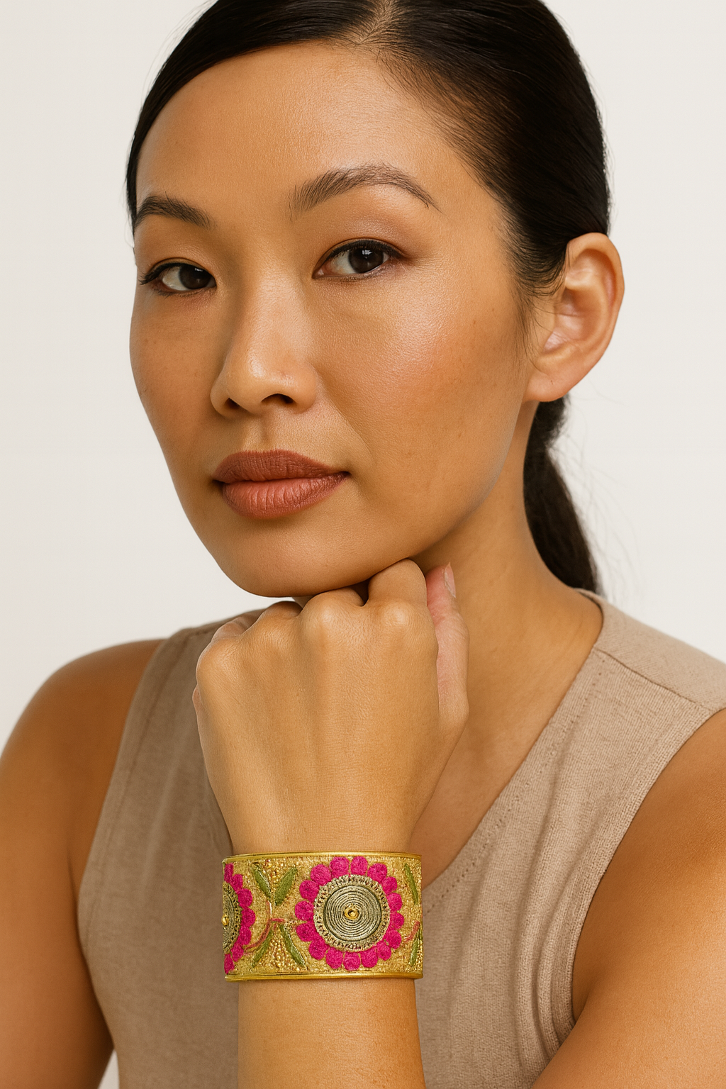 Woman wearing the Redd Dott Peach 2-inch cuff bracelet, crafted in golden fabric and embroidered with bright pink floral designs and green leaf accents for a bold, feminine statement.