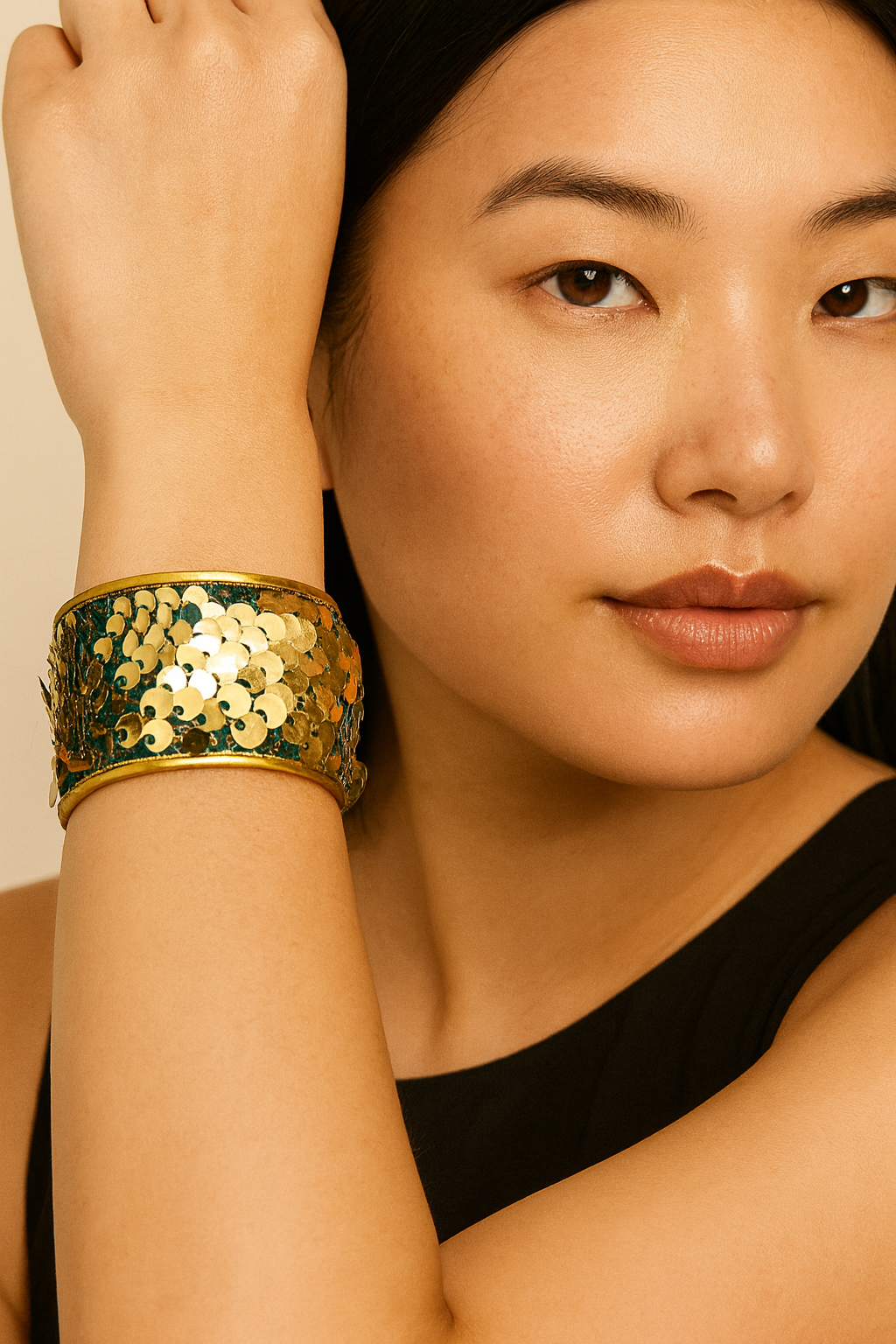 Close-up of a woman wearing the Redd Dott Queen of Mardi Gras 1-inch gold cuff bracelet, featuring a shimmering metallic gold and gold diamond-patterned design.