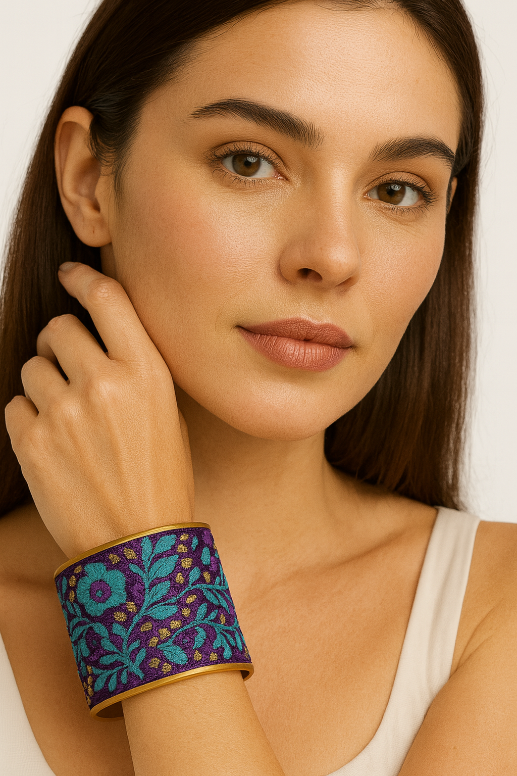 Close-up of a woman wearing the Redd Dott Rachel 3-inch gold cuff bracelet, featuring rich purple fabric with turquoise floral embroidery and small golden accents.