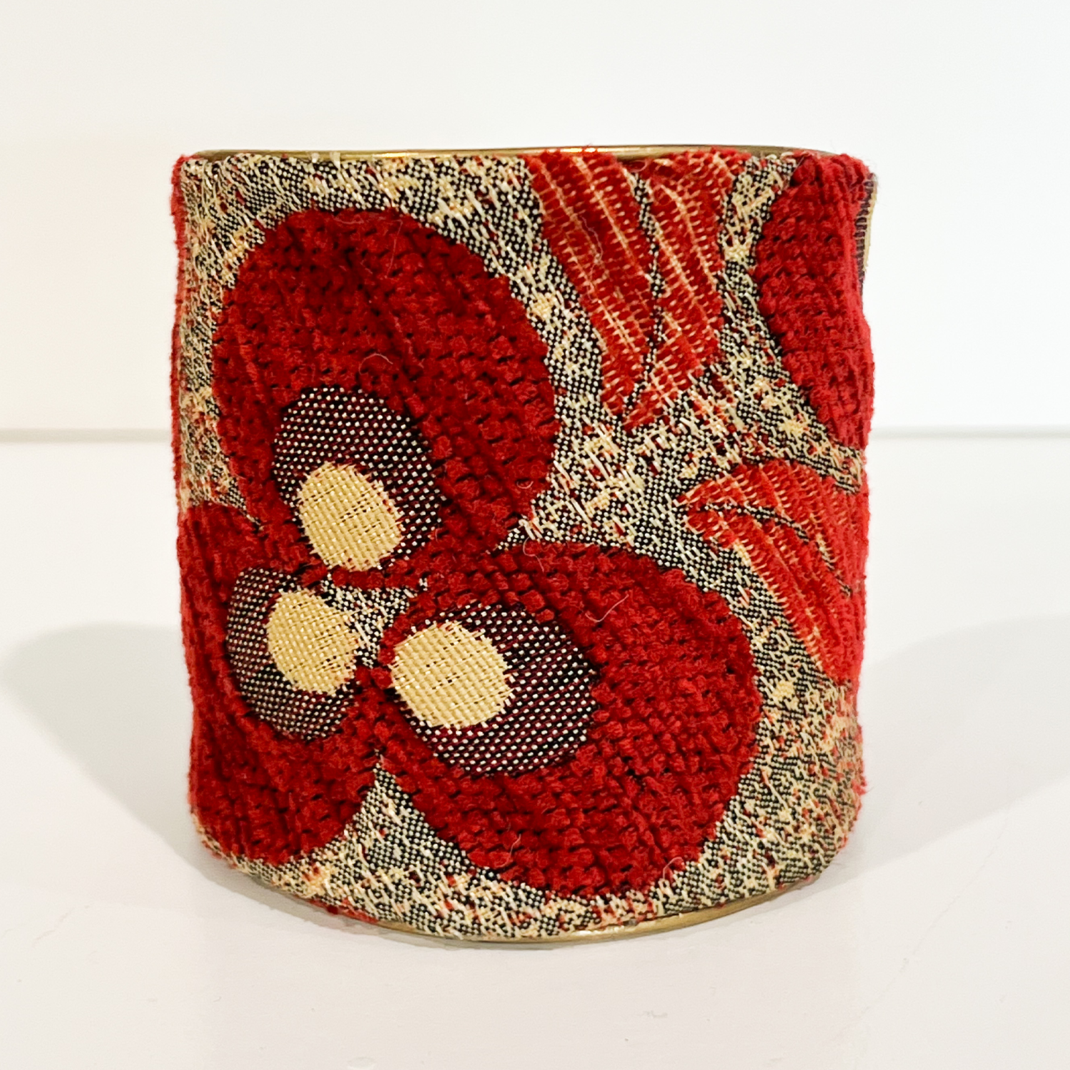 Close-up of Rowan 3-inch red floral statement cuff featuring textured vintage textile and oversized bloom motifs with gold accents, a dramatic wide cuff bracelet, handcrafted in Shreveport, LA by Redd Dott Jewelry.