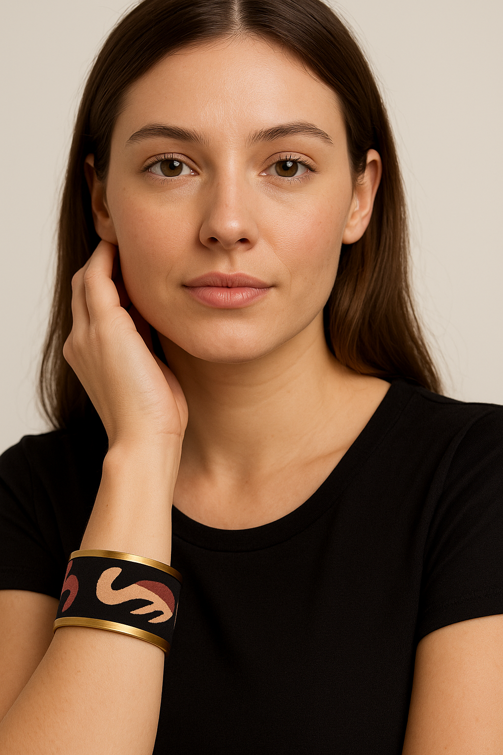 Woman’s wrist wearing the Redd Dott “Sierra” 1″ cuff—black textile with blush and burgundy wave motif, framed by slim brushed-brass rims and an open back; styled with a black tee.