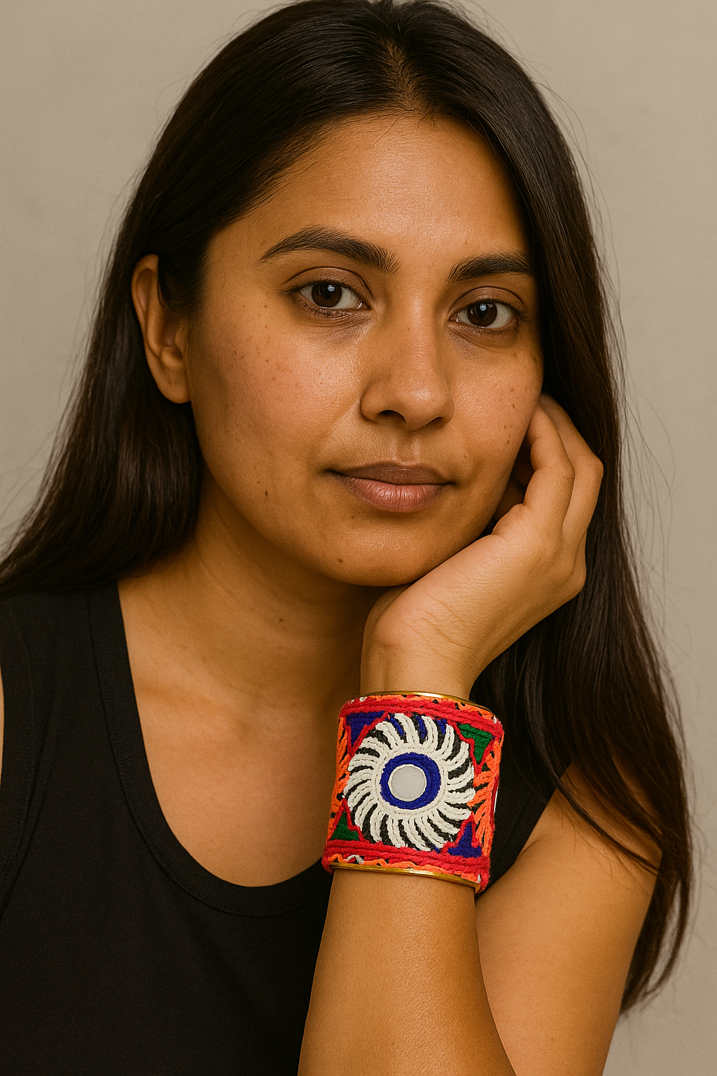 A woman wearing a 2-inch embroidered brass cuff bracelet with mirror accents and bold sunburst patterns in bright colors, showcasing an empowering piece of inspirational jewelry and modern embroidered jewelry.