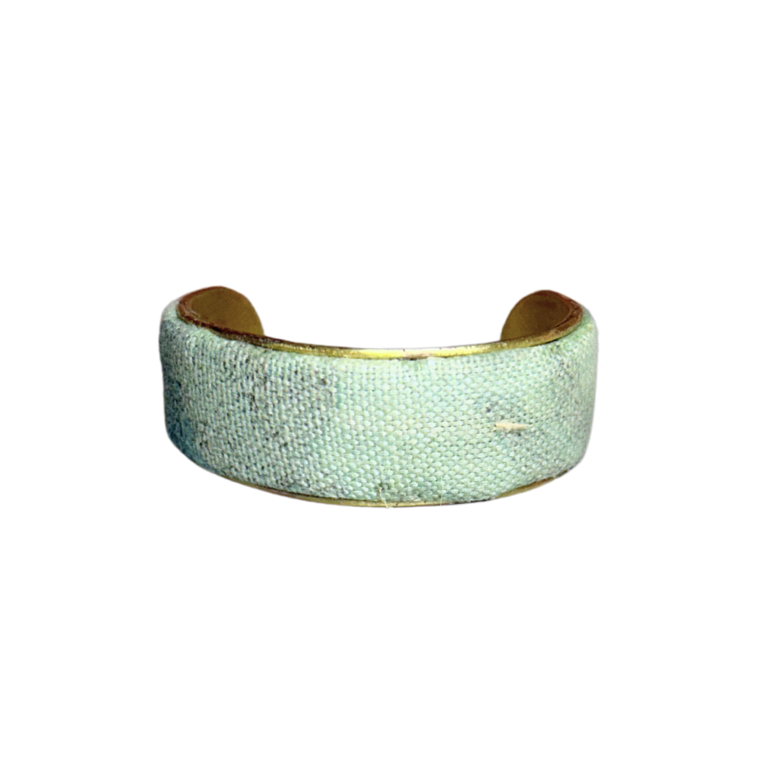 A handmade brass cuff bracelet from Redd Dott Jewelry, crafted and stamped in Shreveport, LA. Features painted sky blue fabric over a vintage brass base—an expressive piece of inspirational jewelry.