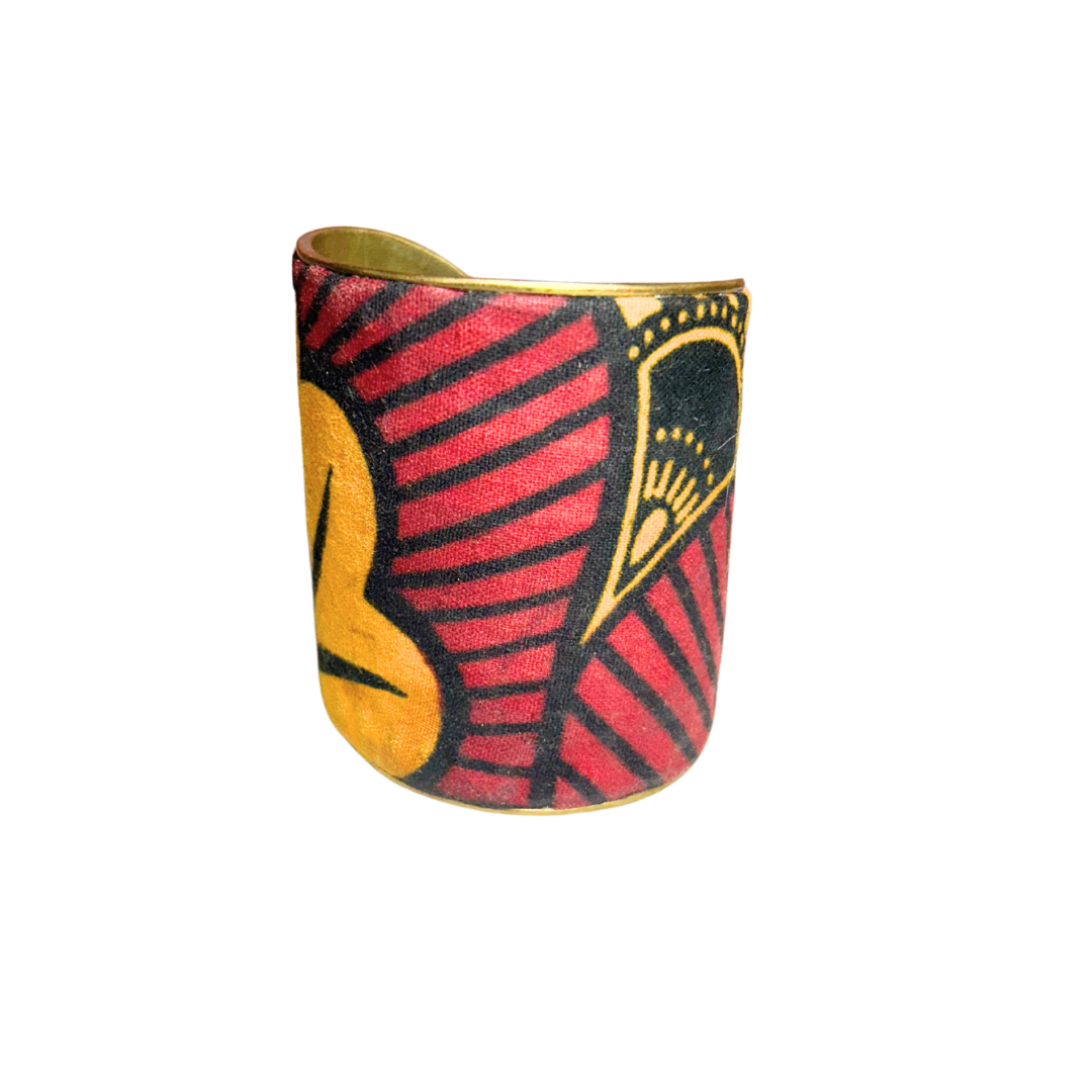 A handcrafted brass cuff bracelet by Redd Dott Jewelry featuring bold crimson, black, and mustard patterns on textured fabric. A dramatic and earthy rustic cuff bracelet with a tribal-inspired aesthetic.







