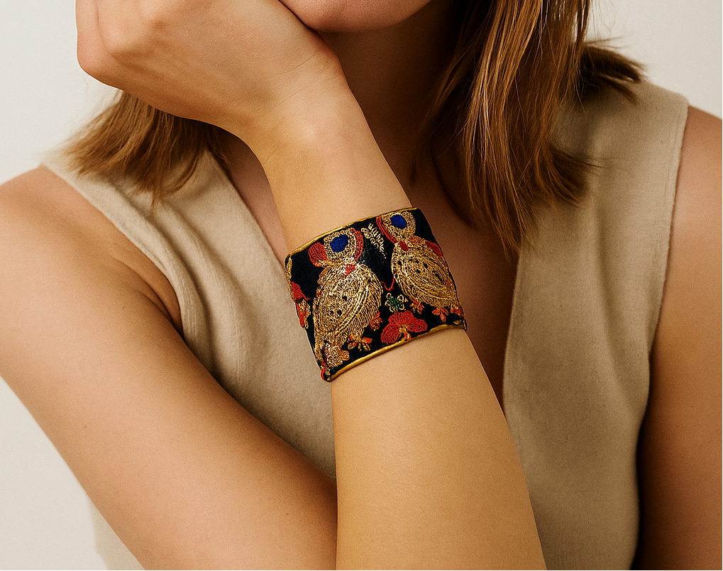 Model wearing the Estelle embroidered cuff bracelet with gold birds and florals, a striking custom bracelet design handcrafted in Shreveport, LA by Redd Dott Jewelry.