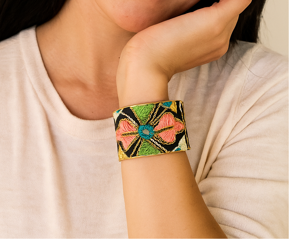 Model wearing the 2-Inch Arden Brass Cuff Bracelet featuring vibrant vintage saree fabric with coral, green, and blue embroidery on black background, handcrafted in Shreveport, LA by Redd Dott Jewelry.